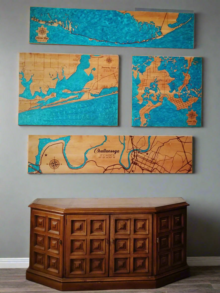 Set of four wooden maps on a wall above a wooden cabinet.