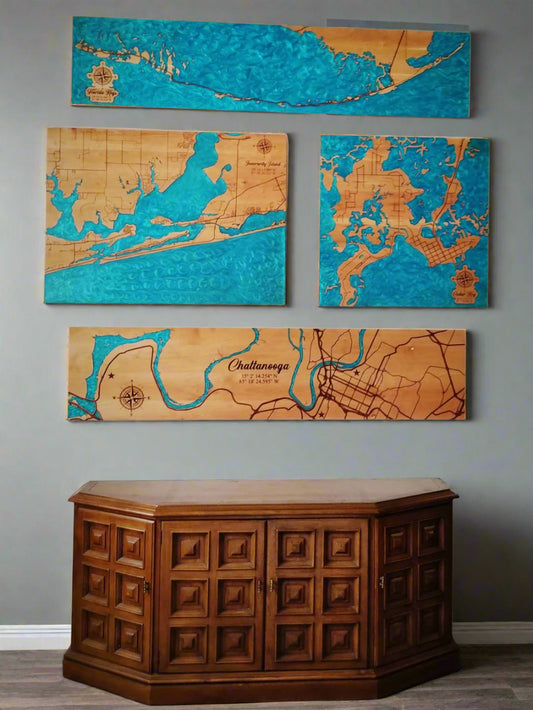 Set of four wooden maps on a wall above a wooden cabinet.